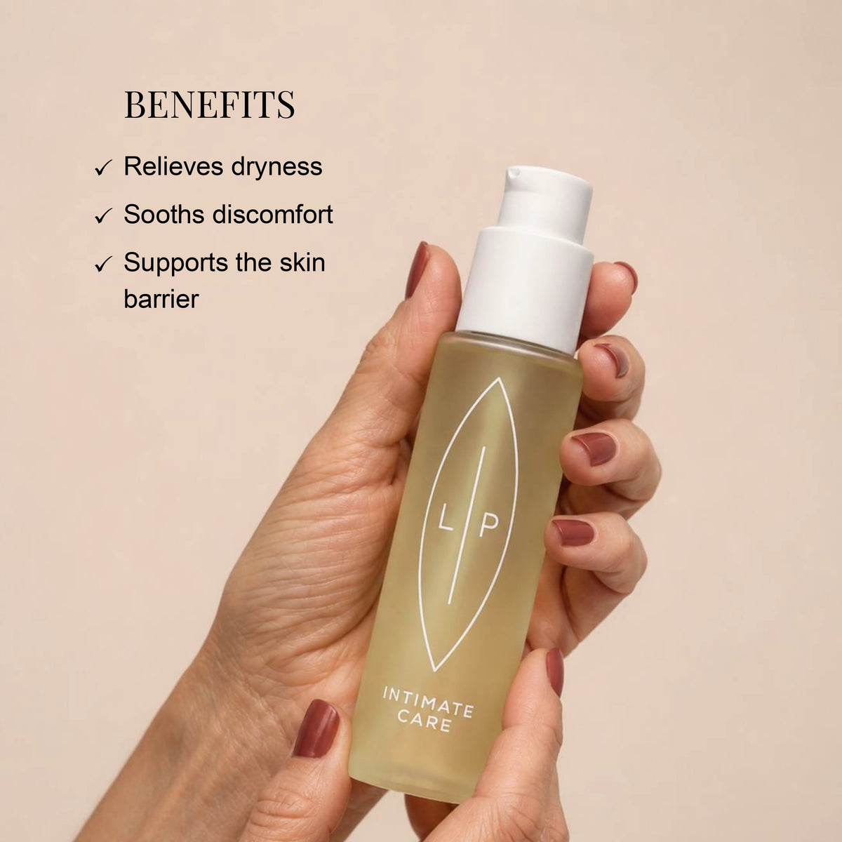 A hand with mauve nail polish holds a frosted bottle of LP Intimate Care menopause oil with a white pump.